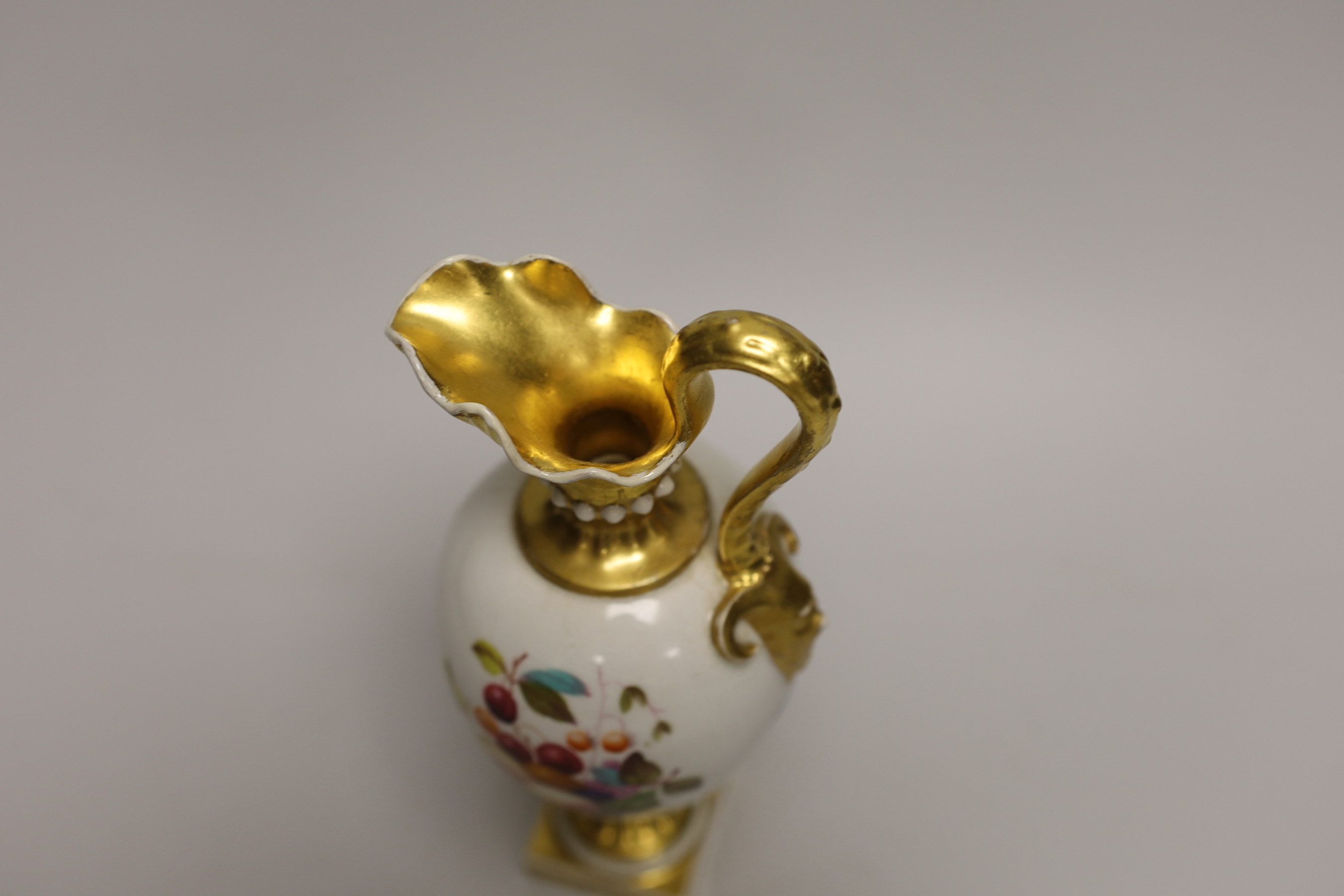 A Derby ewer with mask head handle painted with fruit by Thomas Steele, stamped to the base, 23cm high